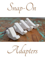A set of white snap-on adapters for sewing machine feet, displayed on a textured background.